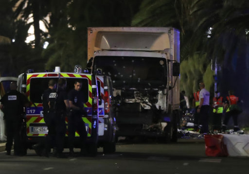 Police officers and rescued workers stand near a van that ploughed into a crowd leaving a fireworks display in the French Riviera town of Nice on July 14, 2016. The mayor of the French city of Nice said dozens of people were likely killed after a van rammed into a crowd marking Bastille Day in the French Riviera resort today and urged residents to stay indoors. / AFP / VALERY HACHE (Photo credit should read VALERY HACHE/AFP/Getty Images)